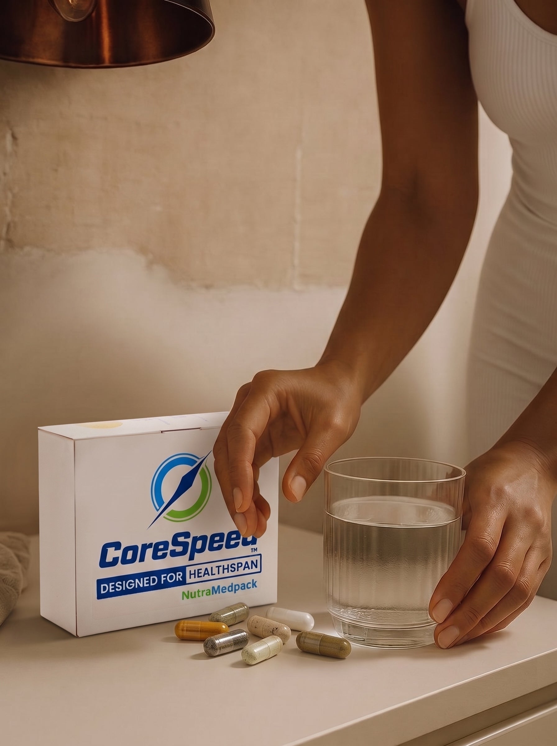 Person reaching toward a CoreSpeed box beside a glass of water